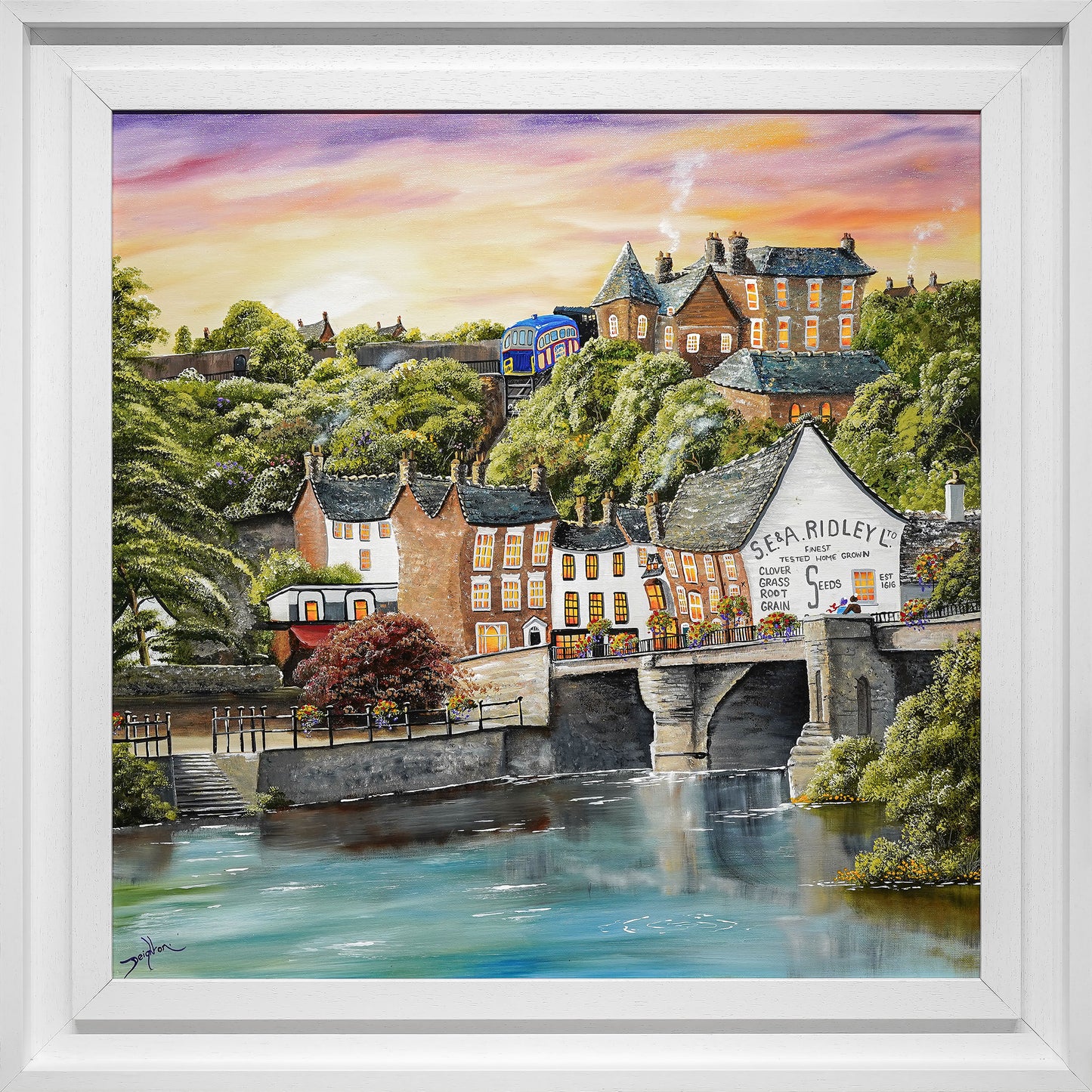 Framed painting of a village scene with houses and a bridge over water.