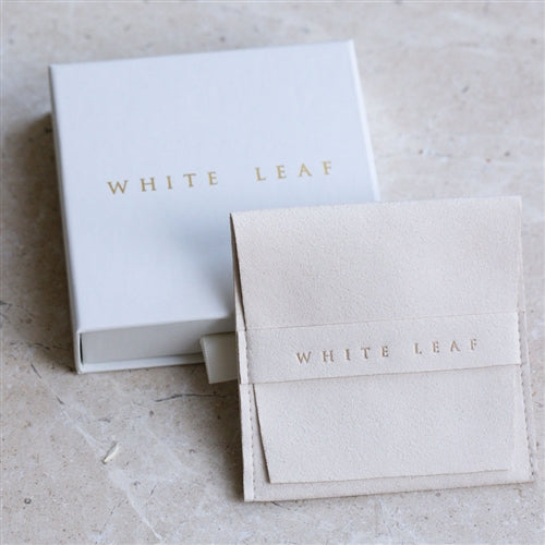 White Leaf jewelry box and pouch on a textured surface