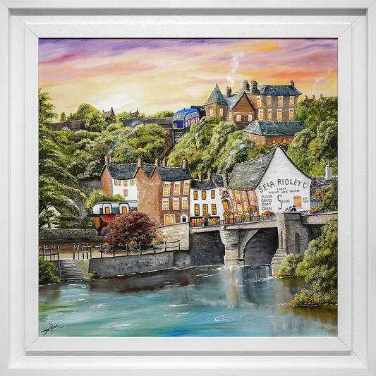 Framed painting of a village scene with houses and a bridge over water.