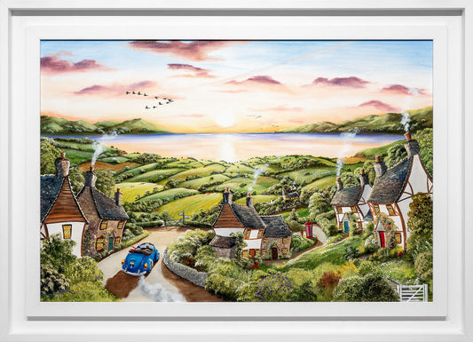 Framed artwork of a scenic village with houses and a car, set against a colorful sky.