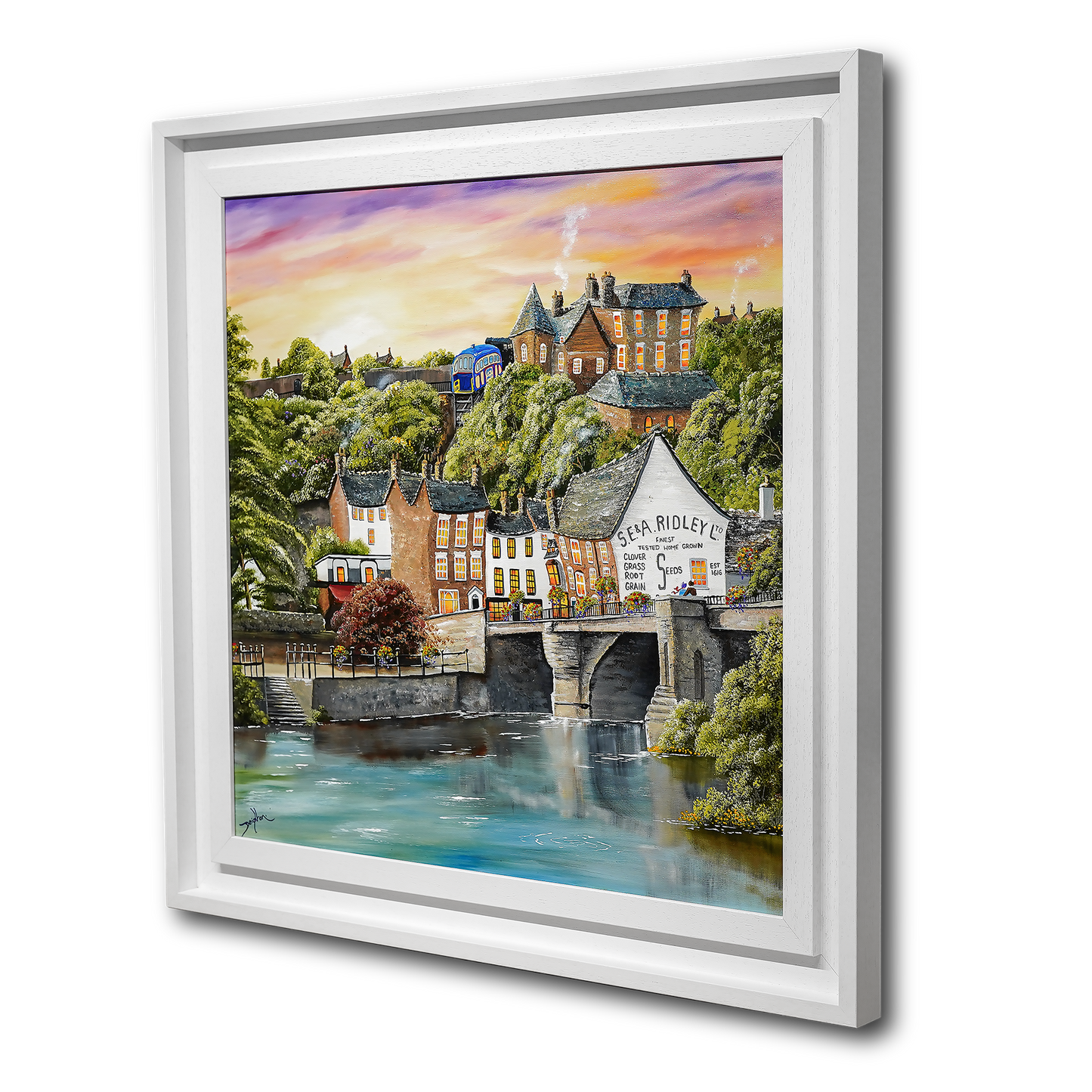 Framed artwork of a scenic town with a river and buildings.