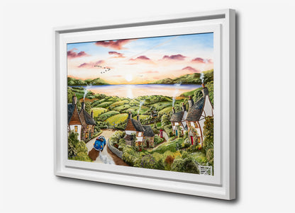 Framed artwork of a scenic landscape with houses and a lake. Caroline Deighton painting