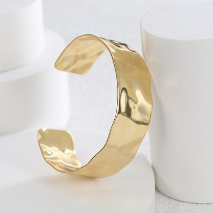 Gold bangle on a white surface