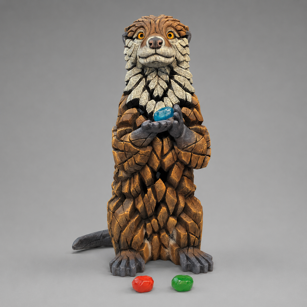 A detailed sculpture of an Otter holding coloured pebbles