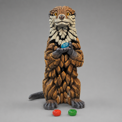 A detailed sculpture of an Otter holding coloured pebbles