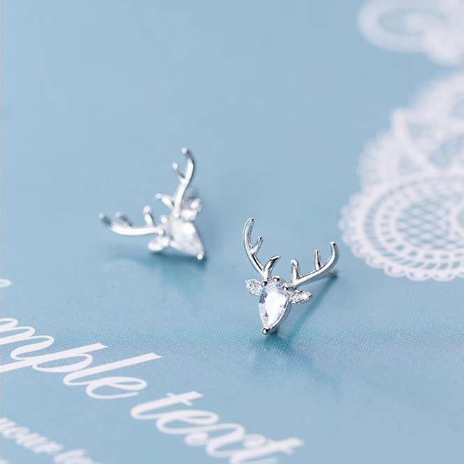 Silver deer antler earrings on a light blue background with white text