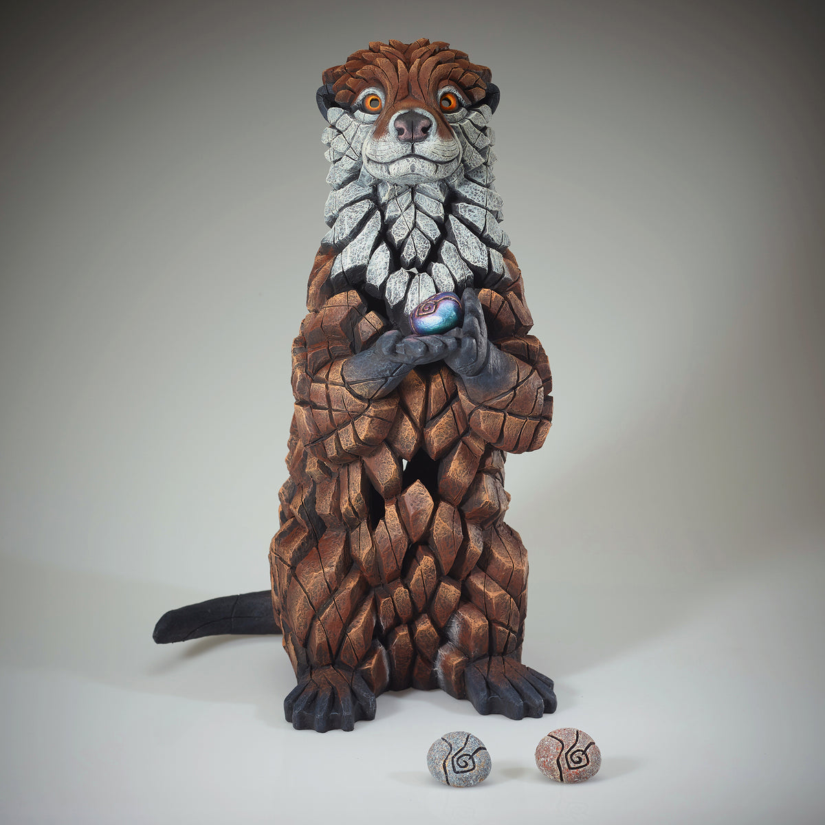 Otter Sculpture from Edge Sculpture by Matt Buckley holding different colour pebbles.