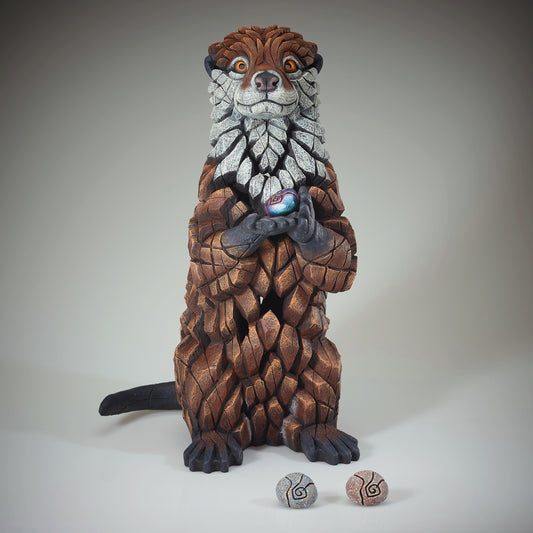 Otter Sculpture from Edge Sculpture by Matt Buckley holding different colour pebbles.