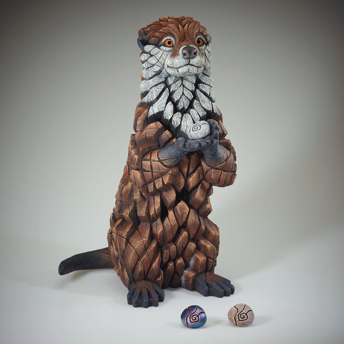 Otter Sculpture from Edge Sculpture by Matt Buckley holding different colour pebbles