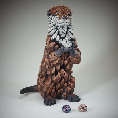 Otter Sculpture from Edge Sculpture by Matt Buckley holding different colour pebbles