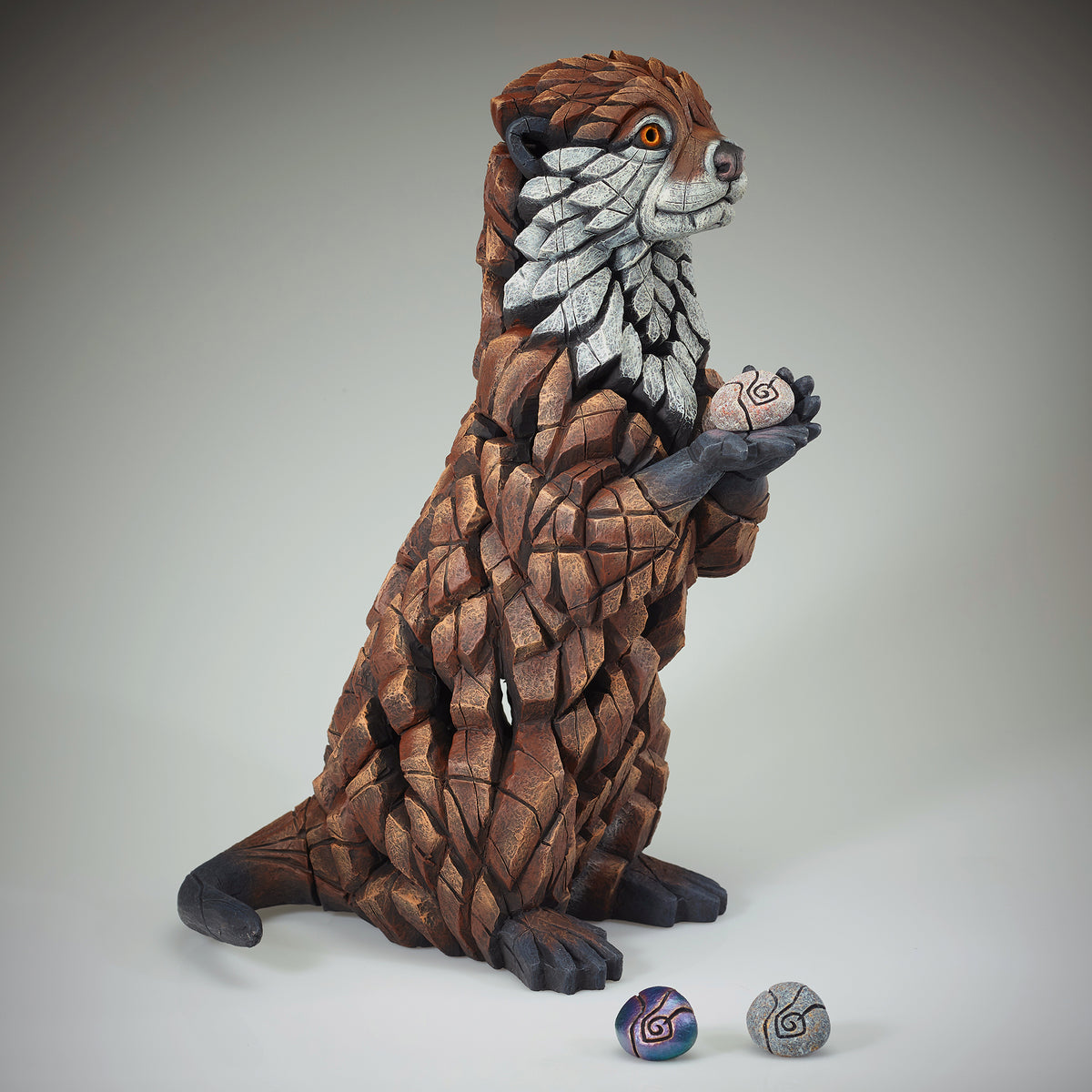 Otter Sculpture from Edge Sculpture by Matt Buckley holding different colour pebbles.