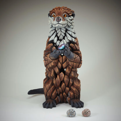 Otter Sculpture from Edge Sculpture by Matt Buckley holding different colour pebbles.