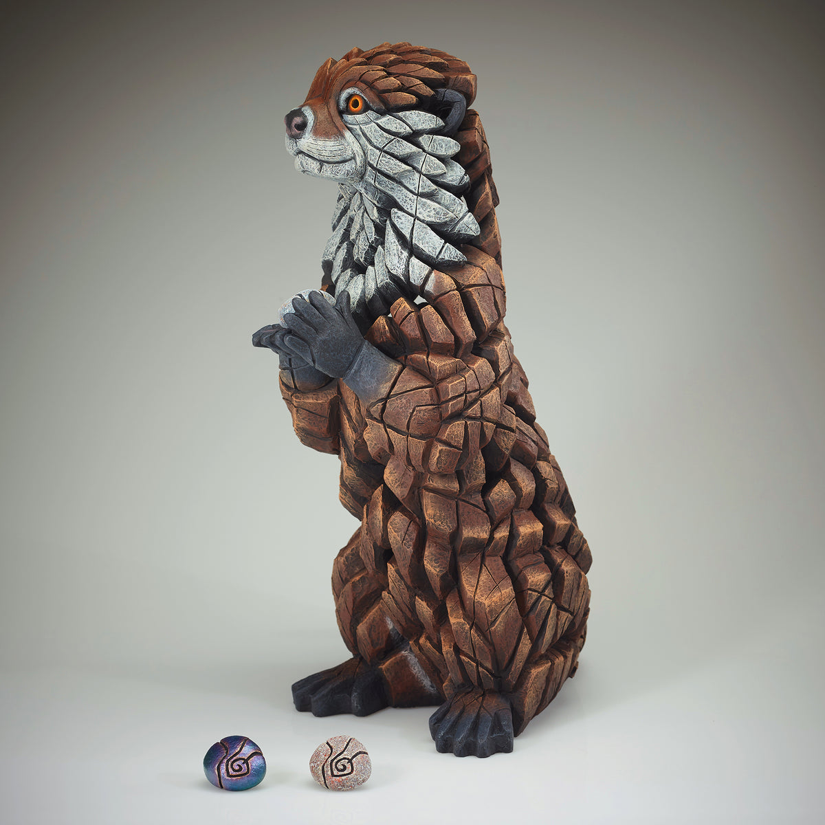 Otter Sculpture from Edge Sculpture by Matt Buckley holding different colour pebbles.