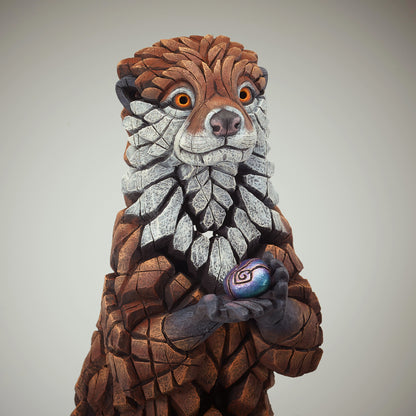 Otter Sculpture from Edge Sculpture by Matt Buckley holding coloured pebble.