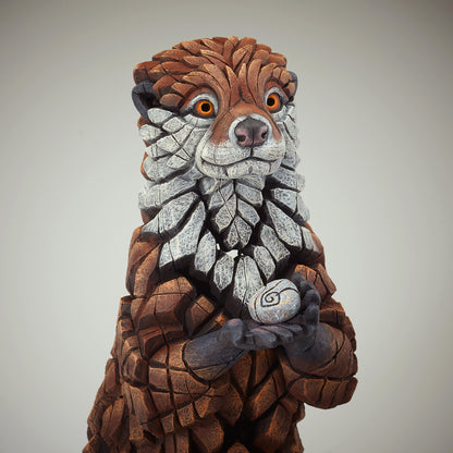 Otter Sculpture from Edge Sculpture by Matt Buckley holding pebble.