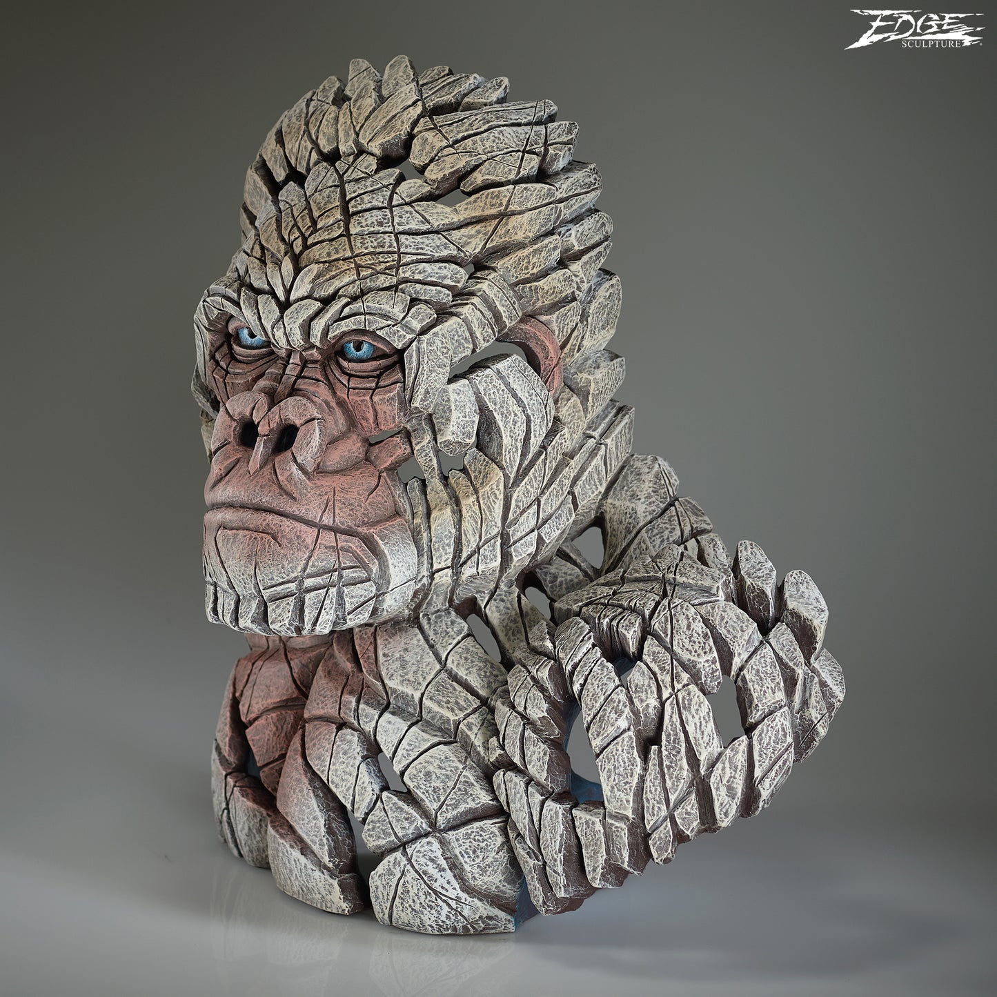 Statue of a gorilla with a textured, stone-like appearance on a gray background