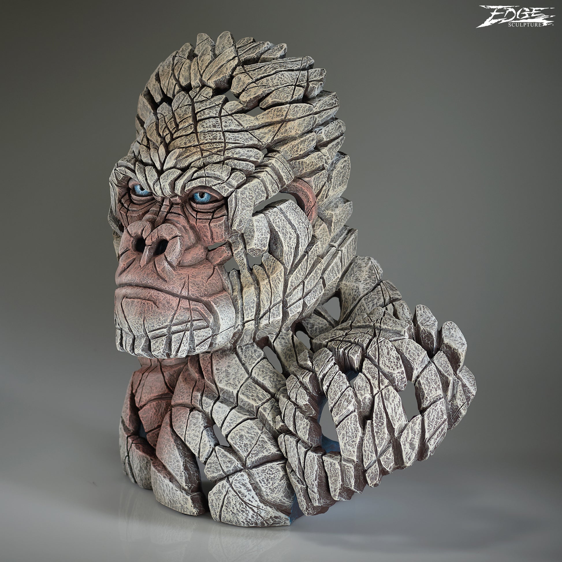 Statue of a gorilla with a textured, stone-like appearance on a gray background