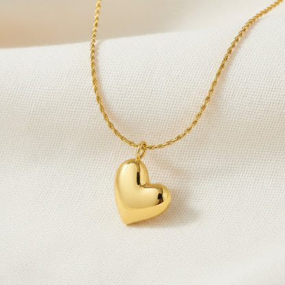Gold heart-shaped pendant necklace on a white background