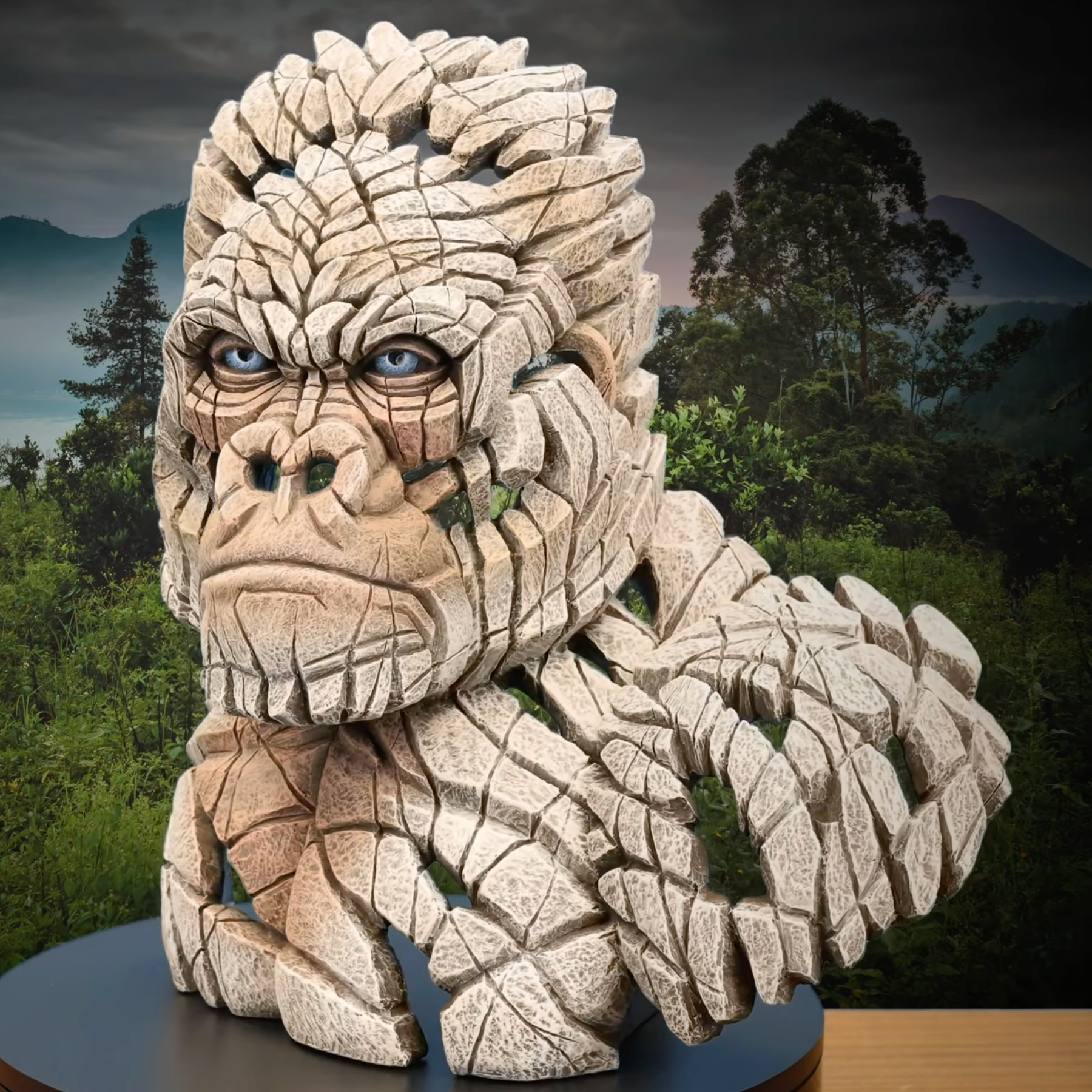 Stone gorilla sculpture with a natural landscape background