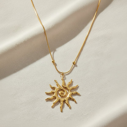 Gold sun-shaped pendant necklace on a white background