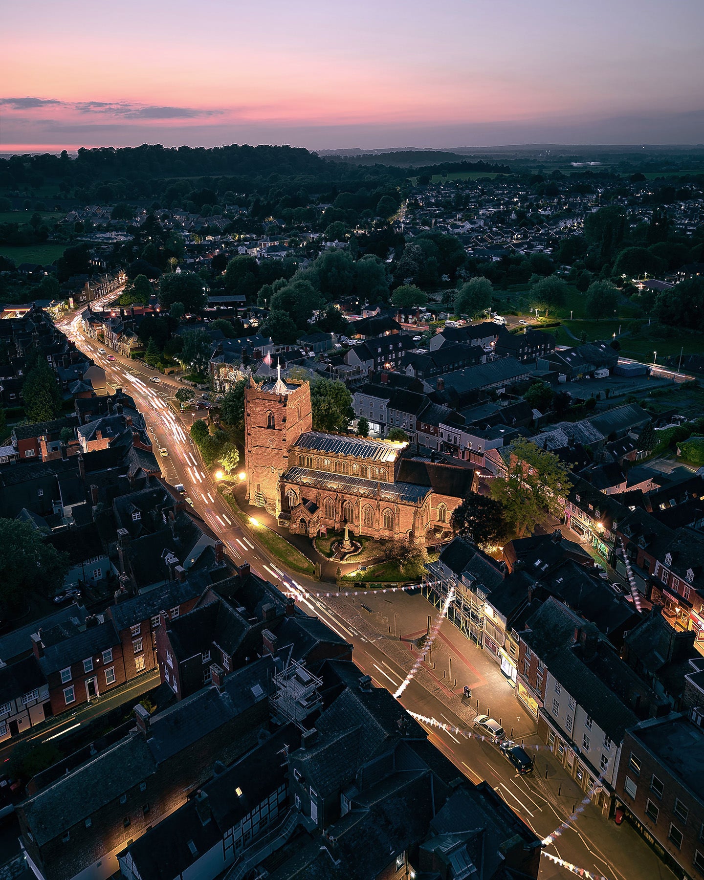 Aerial drone photo of St Nicholas church in Newport Shropshire, road, sunset, light trails