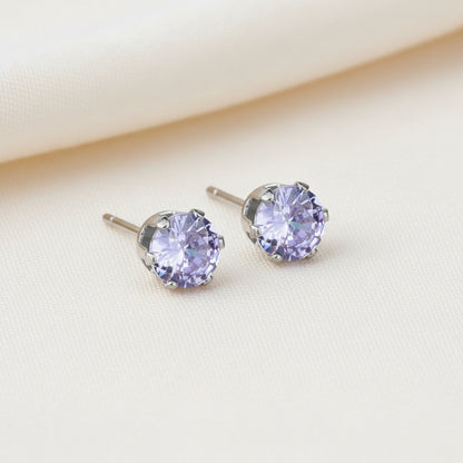 Pair of stud earrings with purple gemstones on a white background