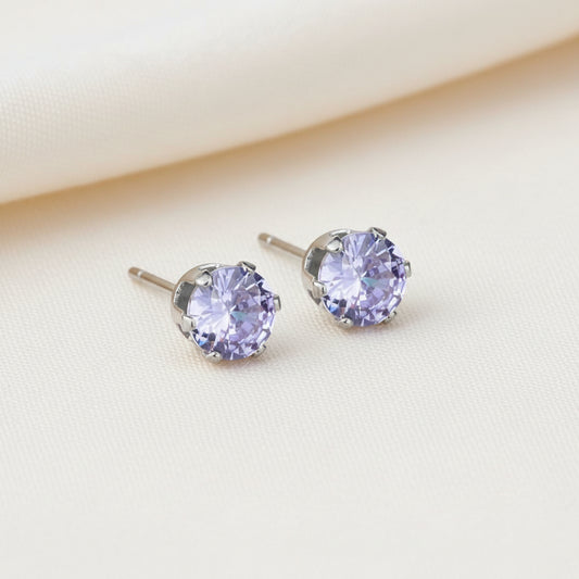Pair of stud earrings with purple gemstones on a white background