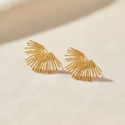 Gold earrings with a fan-like design on a white background