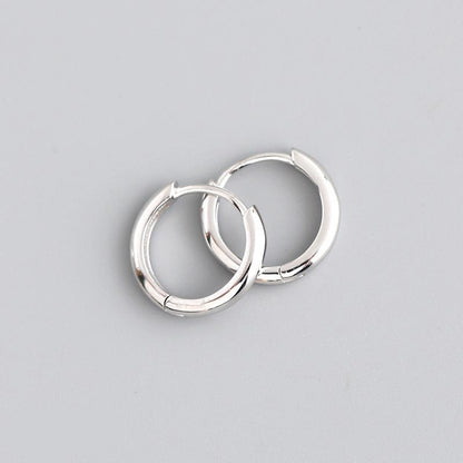 Pair of silver hoop earrings on a gray background