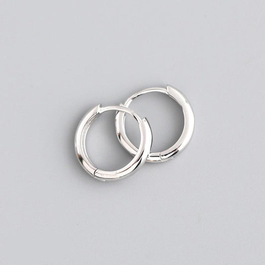 Pair of silver hoop earrings on a gray background