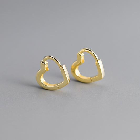 Gold heart-shaped hoop earrings on a gray background